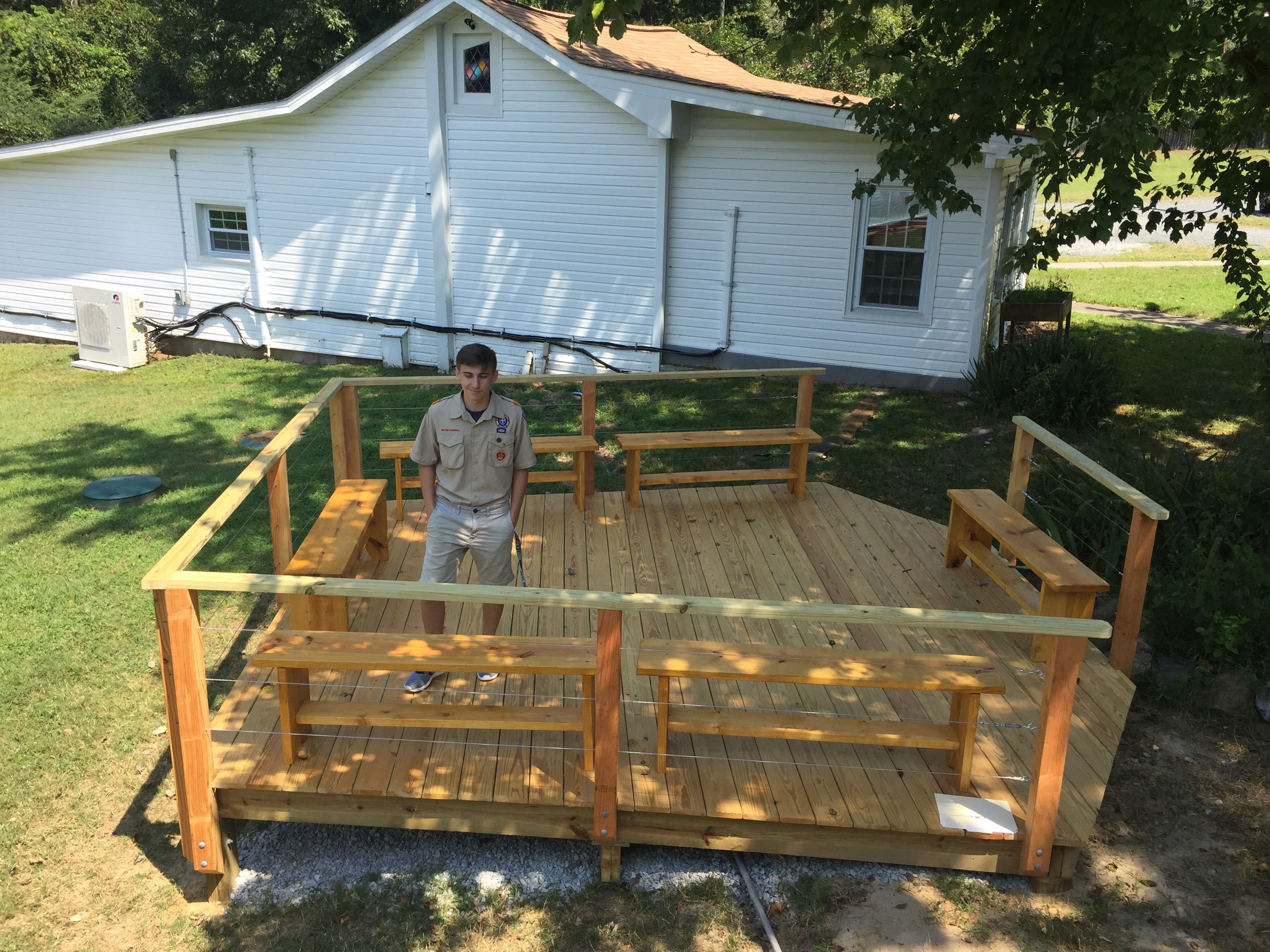 Christopher Jamrog poses on the deck  that he and volunteers built