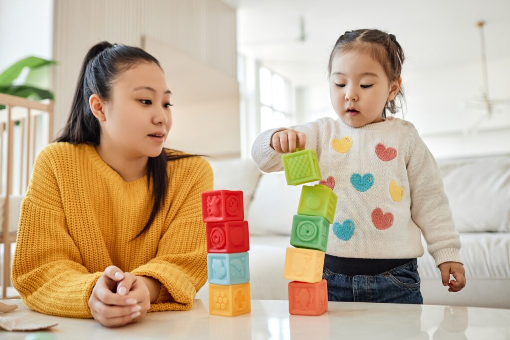 mother and young daughter playing with blocks