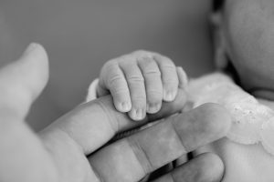 Newborn baby hand on hands