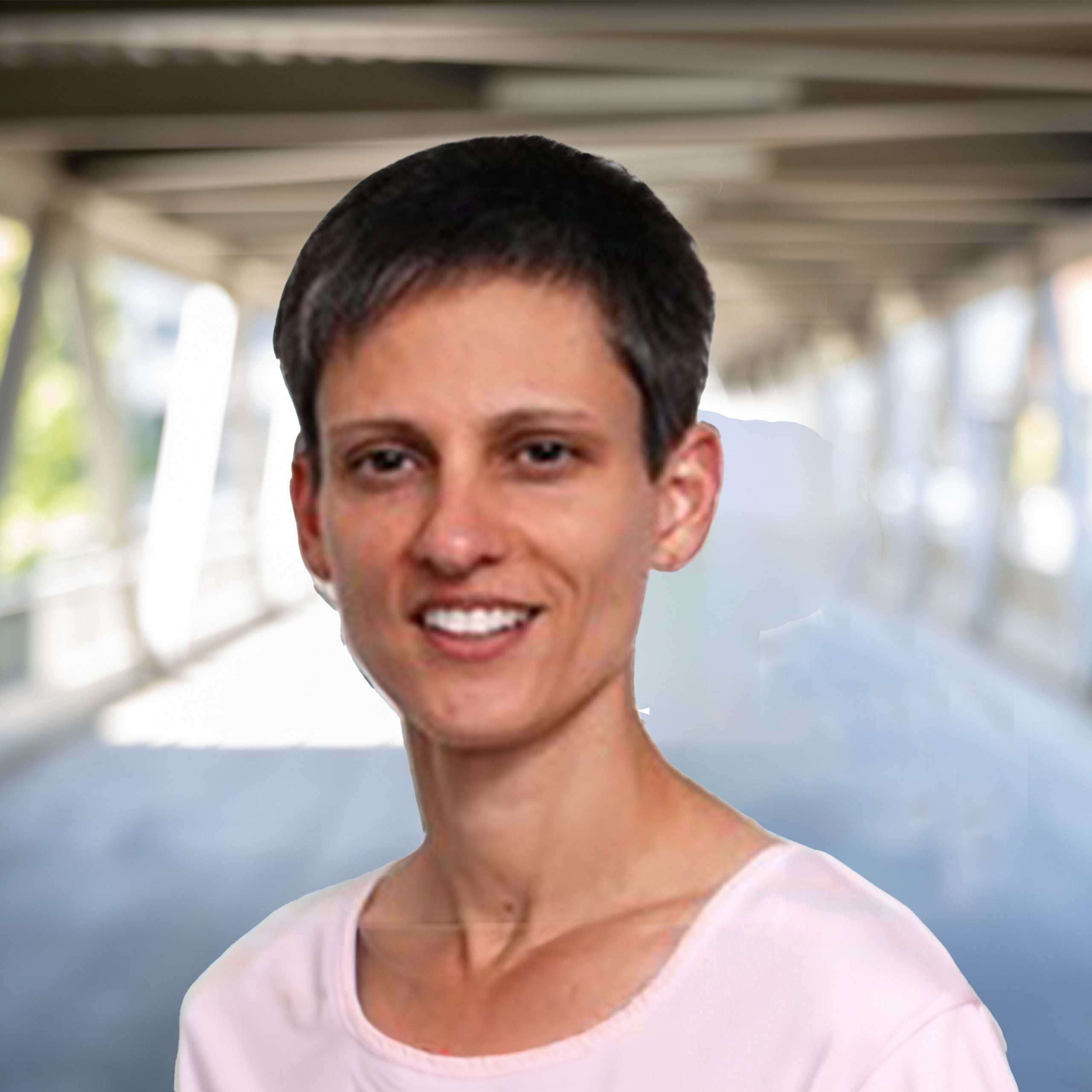 Cherie Kuzmiak headshot. A female with a pixie cut and brown eyes smiling at the camera. She is wearing a light pink shirt.