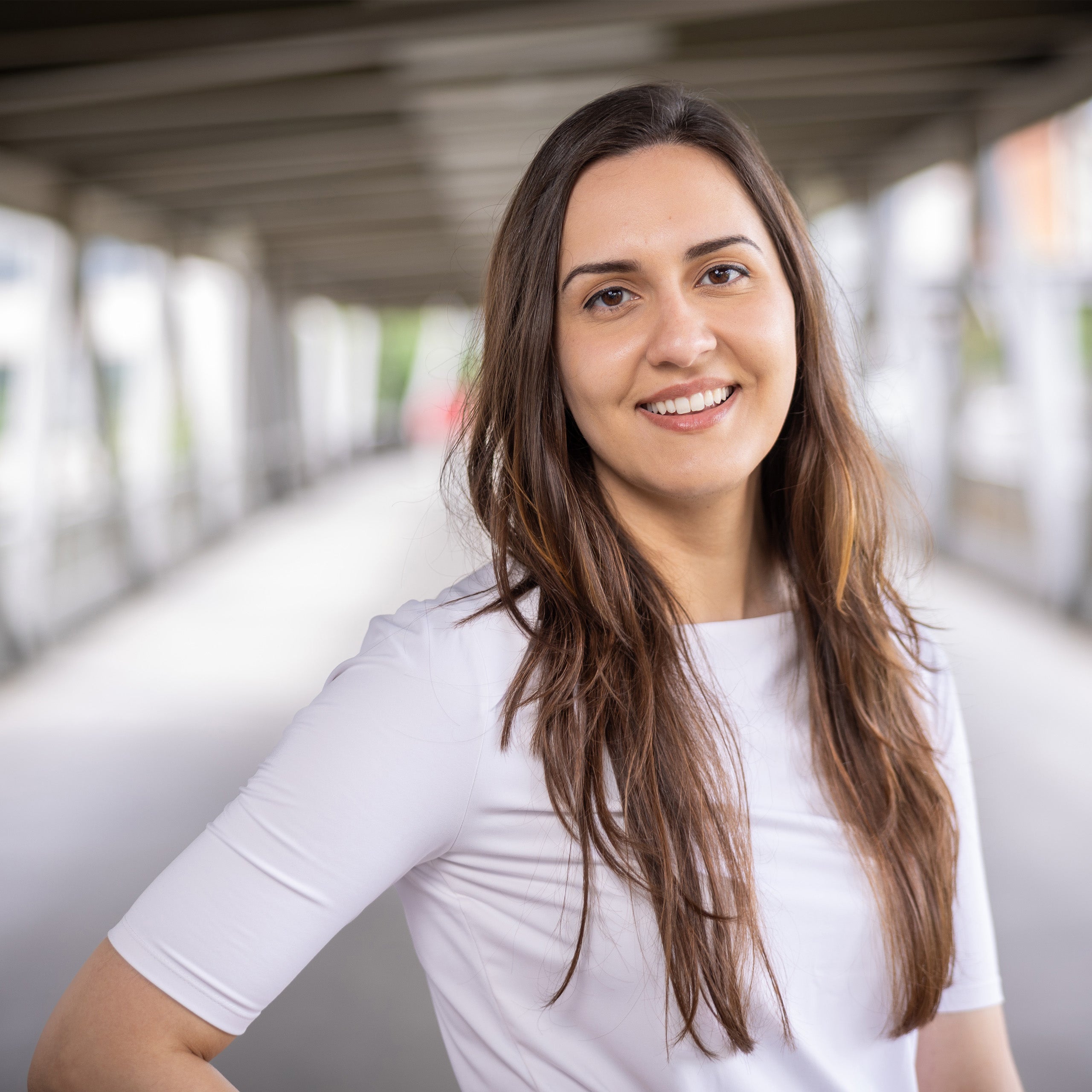 Rachel Bright headshot. Female with long brown hair and eyes is smiling at the camera. She is wearing a white shirt.