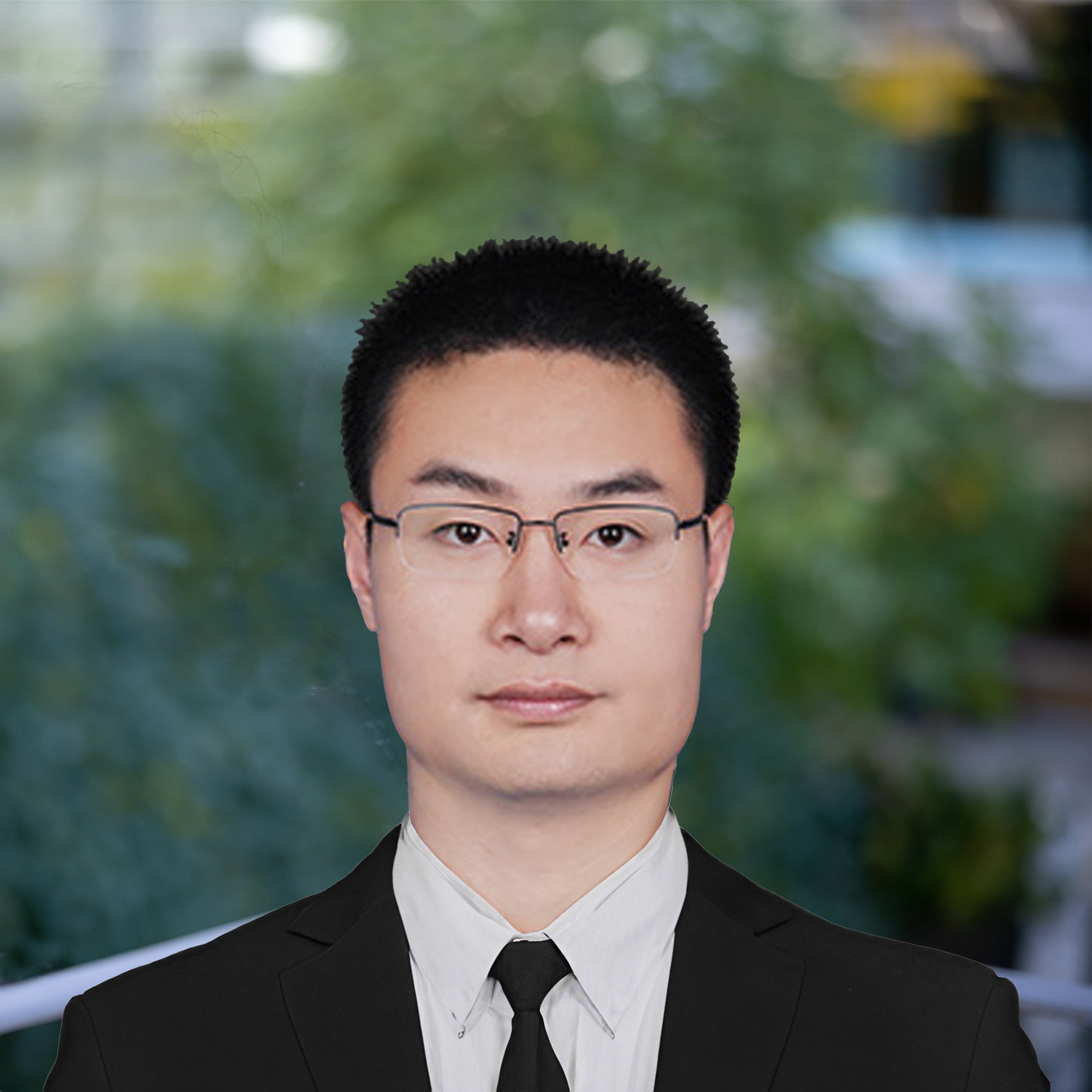 Zhengwang Wu headshot. An Asian male with short black hair and brown eyes wearing glasses is looking at the camera. He is wearing a white shirt, black tie and black jacket. He is standing against an outdoor backdrop.
