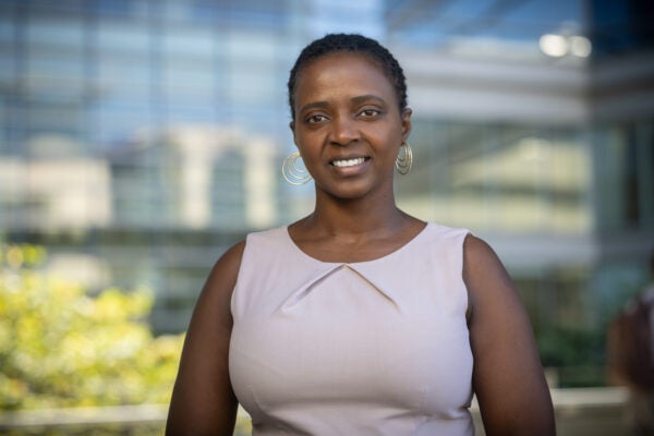 Josephine Muiruri headshot. Black female smiling at the camera, wearing a sleeveless pink dress.