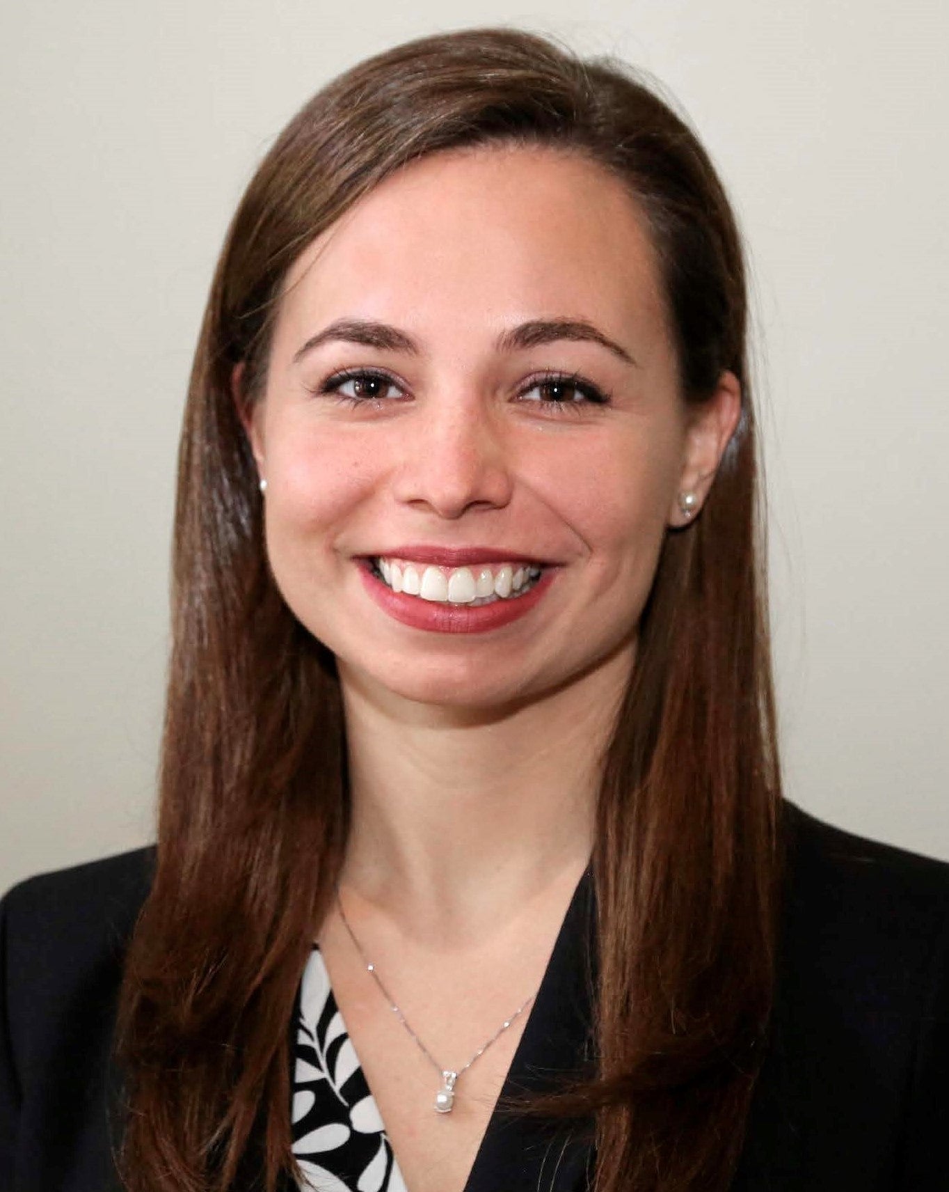 Professional head shot, neutral background, office attire.