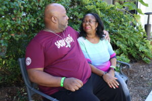 Tolisha & Husband sitting on a bench, looking at each other